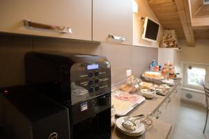 una cucina con forno a microonde e bancone con prodotti alimentari di B&B La Casa di Rosa a Vago