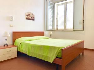 una camera con letto verde e finestra di Appartamenti Sul Mare ad Avola