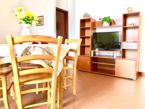 a living room with a table and chairs and a television at Appartamenti Sul Mare in Avola