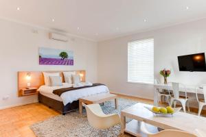 a bedroom with a bed and a dining room at Albourne Guesthouse in Somerset West