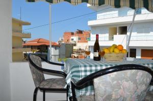 a table with a bottle of wine and a basket of fruit at Villa Viktor in Sarandë