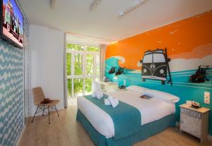 a bedroom with a large bed with an orange wall at Casual de las Olas San Sebastián in San Sebastián