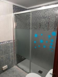 um chuveiro com pontos azuis no vidro em Apartamento La Gloria em Gibaja