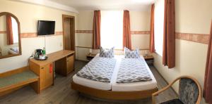 ツィノヴィッツにあるKastanienhof Hotel garniのベッドと鏡が備わるホテルルーム