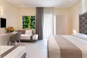 Habitación de hotel con 2 camas y sofá en Palazzo Tritone & Abagnale en Sorrento