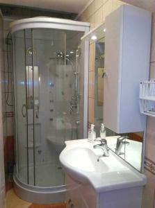 een badkamer met een douche, een wastafel en een wastafel bij FERJOE'S HOME APARTMAN in Boedapest
