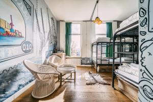 ロッテルダムにあるキング コング ホステルの二段ベッド、テーブル、椅子が備わる客室です。