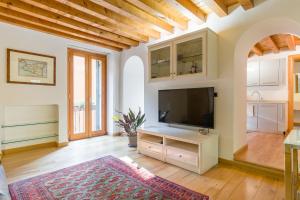 a living room with a flat screen tv on a stand at Downtown Apartment Verona in Verona