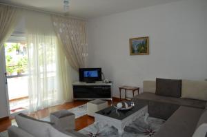 a living room with a couch and a tv at Villa Viktor in Sarandë