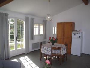 uma cozinha com uma mesa com cadeiras e um frigorífico em Résidence Miro em Les Arcs sur Argens