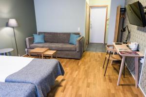 a hotel room with a bed and a couch at Nordens Ark Bed and Breakfast in Stranderäng