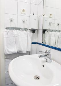 a bathroom with a sink and a mirror and towels at Nordens Ark Hotell in Stranderäng