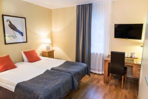 a hotel room with a bed and a desk at Nordens Ark Hotell in Stranderäng