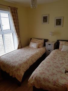 a bedroom with two beds and a window at Beech House in Portballintrae
