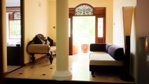 a living room with a couch and a chair and a mirror at Vivid Colombo in Colombo
