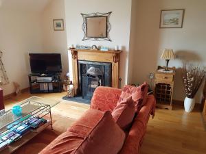 a living room with a couch and a fireplace at Beech House in Portballintrae