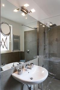ein Bad mit einem Waschbecken, einer Dusche und einem Spiegel in der Unterkunft Overseas - Appartamento Attico - Palazzo San Matteo in Palermo