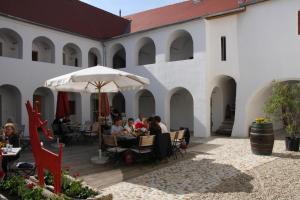 a group of people sitting at tables in a courtyard at Hotel Eisenhuthaus in Poysdorf