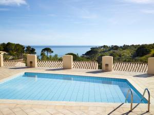 a swimming pool with the ocean in the background at Hapimag Resort Cefalù in Cefalù