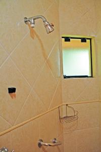 a shower with a mirror and a shower head at Pousada AlpenRose in Campos do Jordão