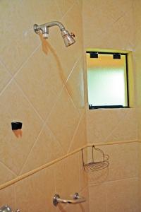 d'une douche avec un miroir et un pommeau de douche. dans l'établissement Pousada AlpenRose, à Campos do Jordão