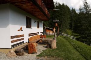 a building with a wooden bench next to a house at Ferienhaus Anderles-Alm in Heiligenblut