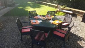 una mesa negra y sillas con comida. en Villa A funtanella en Patrimonio