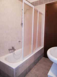 a bathroom with a shower and a tub and a sink at Flower House in Verona