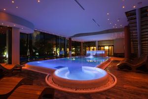 a large swimming pool in the middle of a building at Villa Nicolli Romantic Spa Resort - Adults Only in Riva del Garda