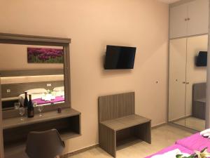 een kamer met een bed en een tv aan de muur bij Pavlos studios in Laganas
