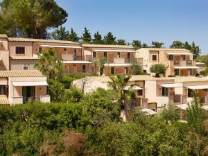 a row of apartment buildings on a hill with trees at Hapimag Resort Cefalù in Cefalù +21 photos