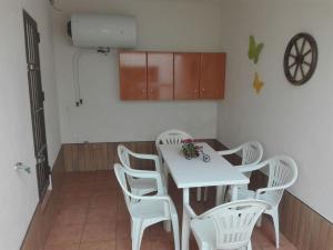 cocina con mesa blanca y sillas blancas en Casa 100m2, en Chiclana de la Frontera
