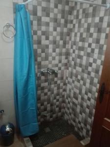 y baño con ducha y cortina azul. en Casa 100m2, en Chiclana de la Frontera