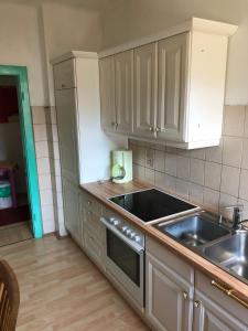 a kitchen with white cabinets and a sink at Kunterbunt Seehaus in Faak am See