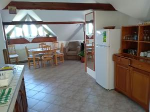 a kitchen with a refrigerator and a table and chairs at Koko Apartman in Tihany
