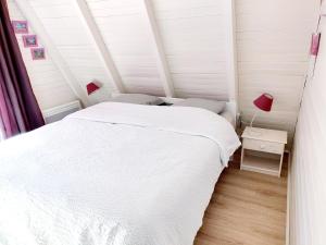 a bedroom with a white bed and two chairs at La Rossignolerie - Cabane aux oiseaux in Chouzy-sur-Cisse