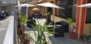 a restaurant with potted plants and umbrellas on a street at Hotel Villa Costa in Celle Ligure