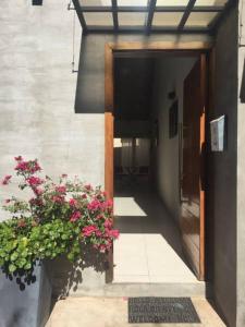 an entrance to a building with pink flowers in a pot at Madre Natura in Asuncion
