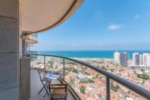 Cosy and sunny apartment in Nevet Tsedek with pool في تل أبيب: شرفة مع كراسي وإطلالة على المحيط