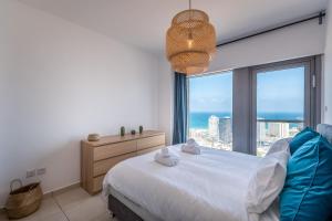- une chambre avec un lit et une grande fenêtre dans l'établissement Cosy and sunny apartment in Nevet Tsedek with pool, à Tel Aviv