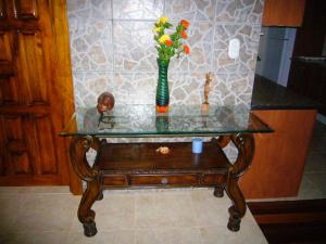 una mesa de cristal con un jarrón con flores. en Villas Pico Bonito, en La Ceiba