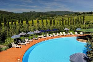 a swimming pool with chairs and umbrellas at Erboli Residence in Cavriglia