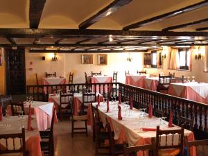 a dining room with tables and chairs with red napkins at Hotel Nuevo Arlanza in Covarrubias