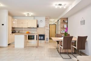 a kitchen and dining room with a table and chairs at Apartman Leon in Umag