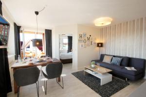 ein Wohnzimmer mit einem Tisch und einem blauen Sofa in der Unterkunft Haus Anna by Rujana in Binz