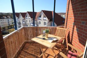 ein Holztisch und Stühle auf einem Balkon in der Unterkunft Haus Anna by Rujana in Binz