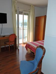 a room with a table and a chair and a balcony at Hotel Capri in Lesa