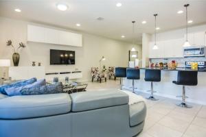 a living room with a couch and a kitchen at Luxurious Vacation Townhome with Private Pool at Windsor at Westside WW8948 in Kissimmee