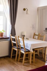 una mesa y sillas con una mesa blanca y una ventana en Apartamenty Madera, en Katowice