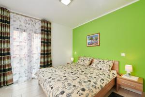 um quarto com uma cama e uma parede verde em Apartman Leon em Umag
